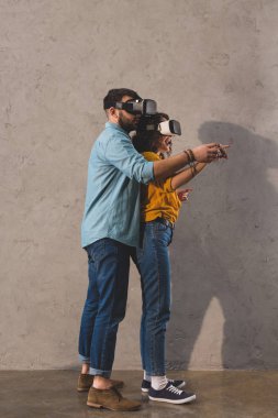 Couple standing and using virtual reality headset clipart