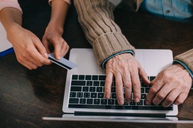 Yakın çekim görünümü laptop ve kredi kartı kullanan yaşlı adam ve kadın