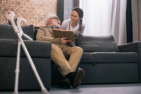 Seniorpatient Mit Buch Gespräch Mit Lächelndem Arzt — Stockfoto