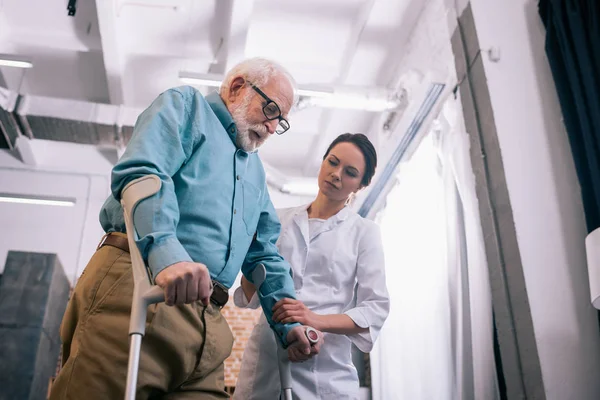 松葉杖で男性患者を支える医師 — ストック写真
