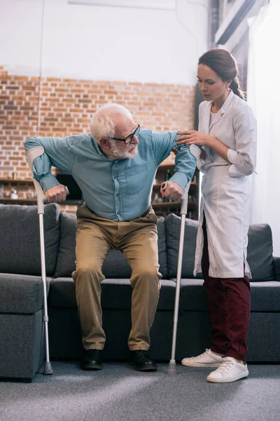 Médico Ajudando Paciente Sênior Com Muletas — Fotografia de Stock