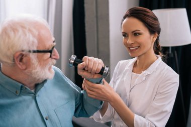 Yaşlı adam ile Halter ve doktor fizik tedavi sırasında