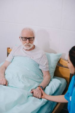 Destekleyen ve komuta sizde hastanın elini tutarak yatakta hemşire
