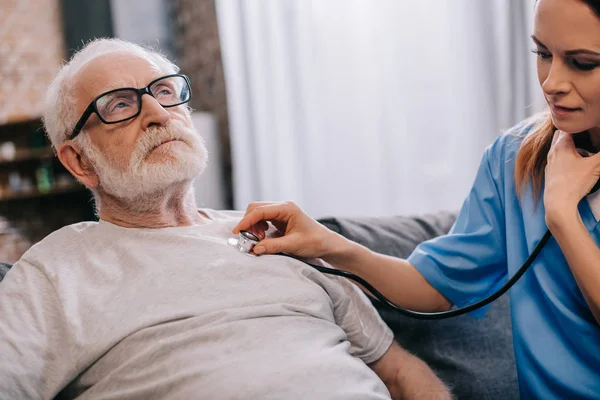 Enfermera Con Estetoscopio Comprobando Latido Del Corazón Del Hombre Mayor — Foto de Stock