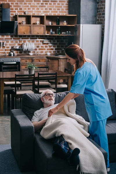 Krankenschwester Deckt Seniorin Mit Plaid — kostenloses Stockfoto