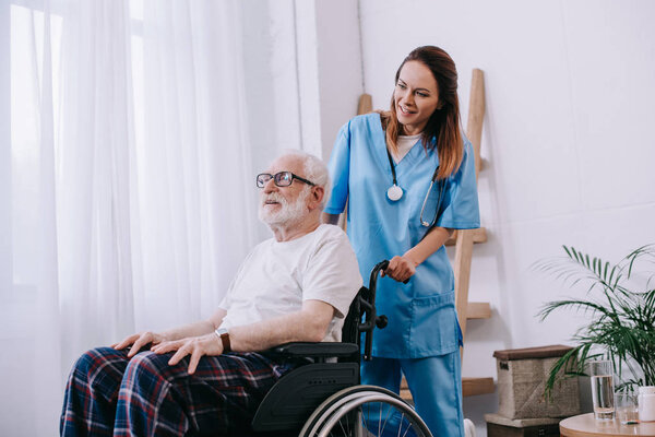 Nurse pushing wheelchair with senior man
