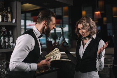 male bartender holding money and shouting at colleague at bar clipart