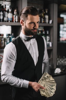 İpuçları tutan mutlu yakışıklı barmen bar