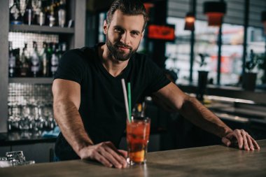 handsome barman standing with alcohol drink at bar counter clipart