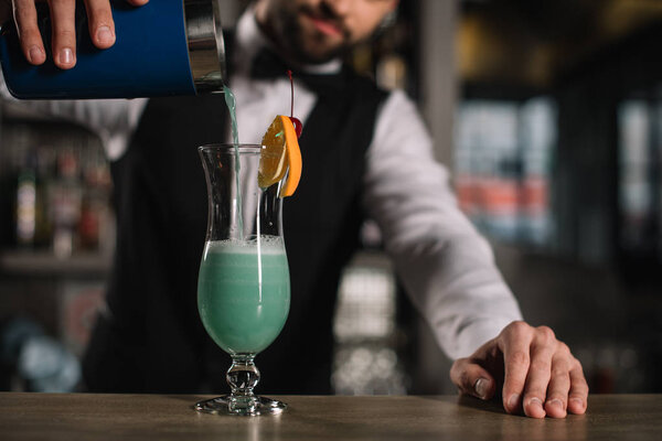 cropped image of bartender preparing alcohol cocktail