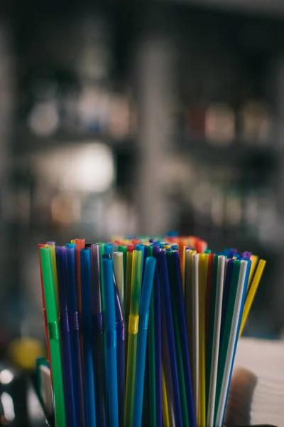 Üzerinde Arka Plan Bulanık Içmek Için Renkli Plastik Çubuk — Stok fotoğraf