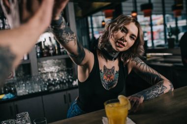 dövmeli barmen ziyaretçisine çak bir beşlik vererek Resim kırpılmış bar