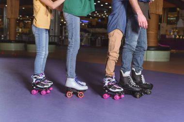 partial view of parents and kids skating on roller rink together clipart