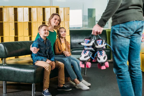 Selectieve aandacht voor het gezin op zoek naar man met roller klapschaatsen voor schaatsen in Skatepark — Stockfoto