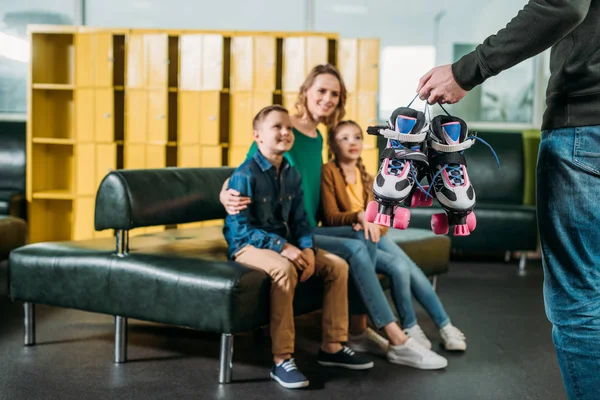 Selective focus of family looking at man with roller skates for skating in skate park — Free Stock Photo