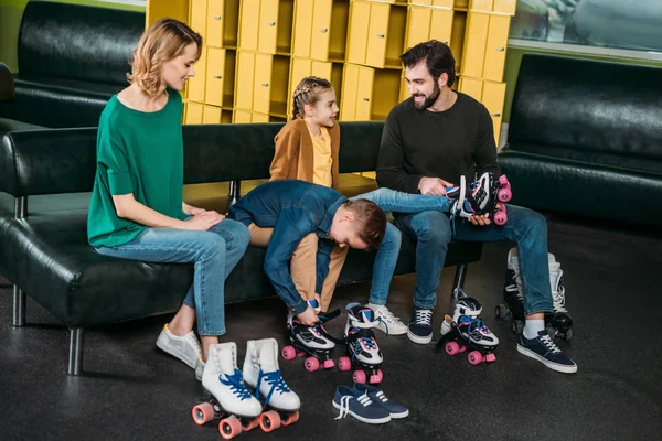 Familia que usa patines antes de patinar en skate park —  Fotos de Stock