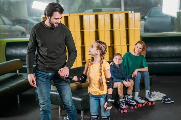 Father and daughter going on roller rink to skate in skate park — Stock Photo, Image