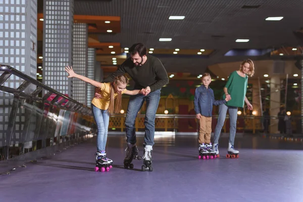 Parents and kids skating on roller rink together — Stock Photo, Image