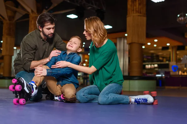 Parents appeasing crying son in roller skates on roller rink — Stock Photo, Image