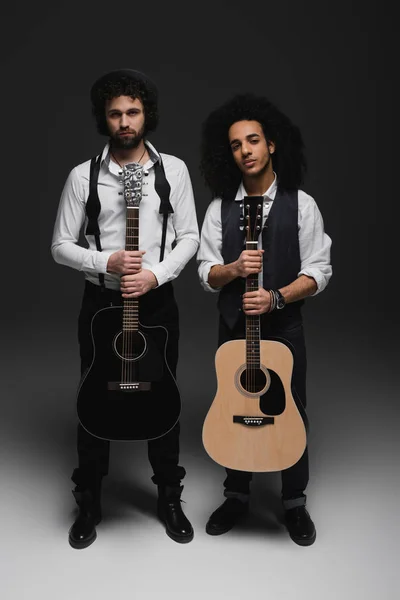 Duet of handsome young musicians with acoustic guitars on black — Stock Photo, Image