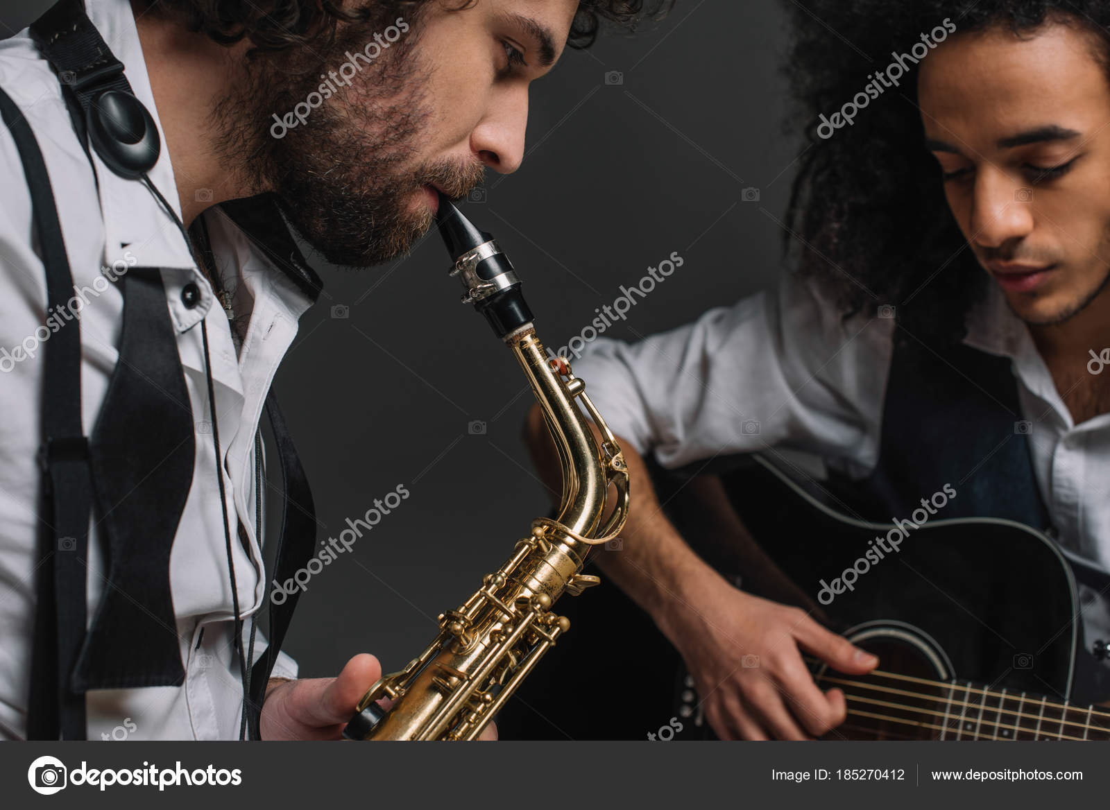 Duet of jazzmen playing sax and acoustic guitar on black ⬇ Stock Photo