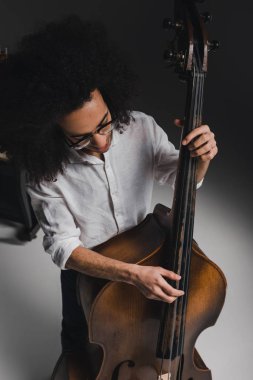 high angle view young man playing standup bass clipart