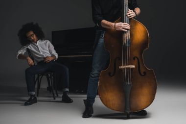 atış viyolonsel depresif ortağı arka plan üzerinde bulanık Piano oturan süre oynayan adamın kırpılmış