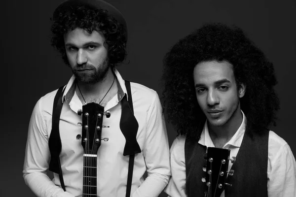 Zwart-wit schot van Duo van musici met akoestische gitaren op zwart — Stockfoto