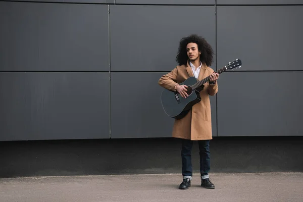 Young street musician playing guitar outdoors — Stock Photo, Image