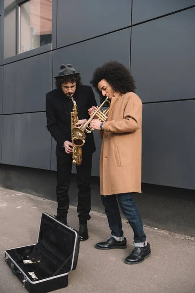 Dueto de músicos de rua elegantes tocando trompete e saxofone ao ar livre — Fotografia de Stock