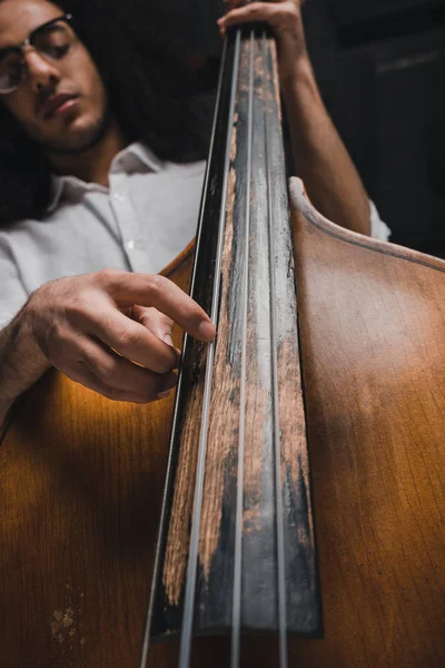 Bottom view of handsome young musician playing standup bass — Stock Photo, Image