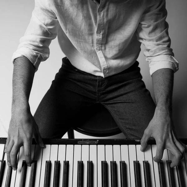 Black and white cropped shot of man playing piano — Stock Photo, Image