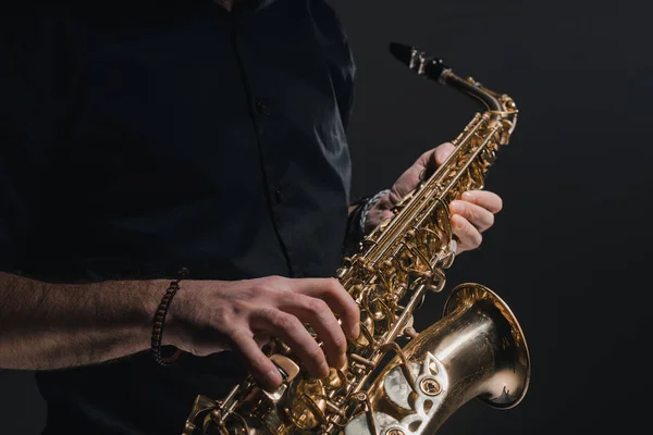 Bijgesneden schot van man saxofoon spelen op zwart — Stockfoto