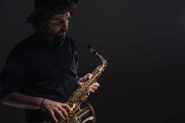 Joven músico tocando saxofón en negro — Foto de Stock