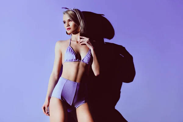 穿着时髦泳装的迷人女孩在紫色 — 图库照片