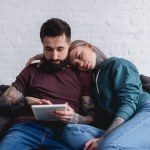 Tatuado casal assistindo algo no tablet em casa