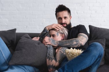 dövmeli çift kanepe evde korku film izlerken