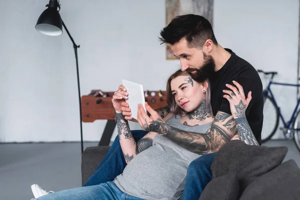 Schwangere Freundin Schaut Mit Freund Auf Sofa Auf Tablet — Stockfoto