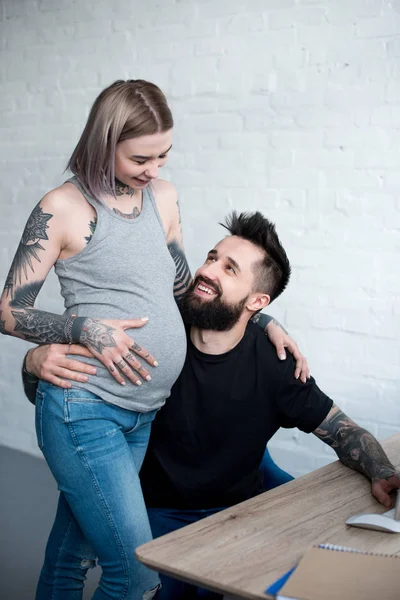 Sorrindo Tatuado Namorado Abraçando Namorada Grávida Casa — Fotos gratuitas