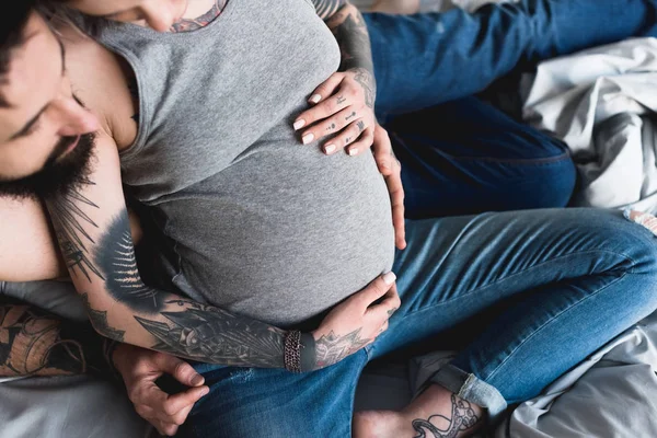 Imagem Cortada Namorado Abraçando Namorada Tatuada Grávida Casa — Fotografia de Stock