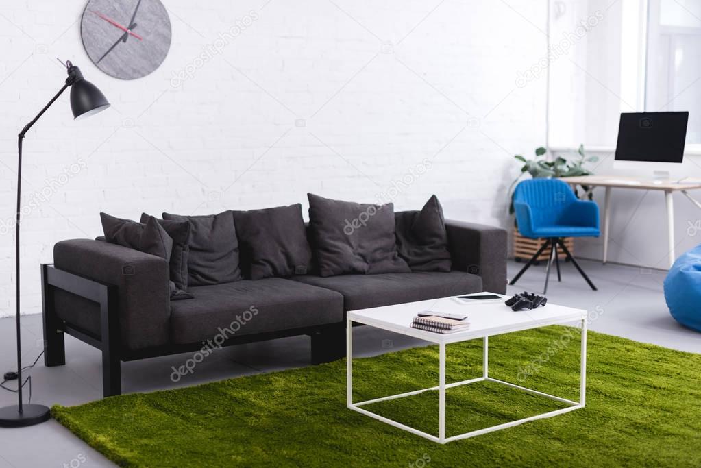 grey sofa and green carpet with tables in living room