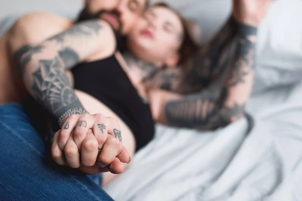 Tatuerade Par Hålla Händerna Säng — Stockfoto