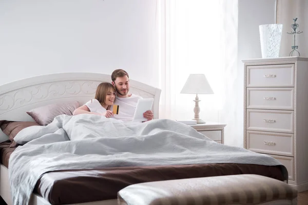 Cuplu Tânăr Culcat Pat Făcând Cumpărături Online Dormitorul Modern — Fotografie, imagine de stoc
