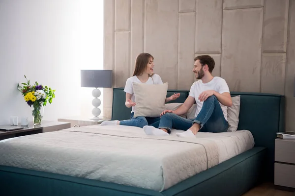 Young Female Holding Pillow Talking Her Boyfriend Modern Bedroom — Stock Photo, Image