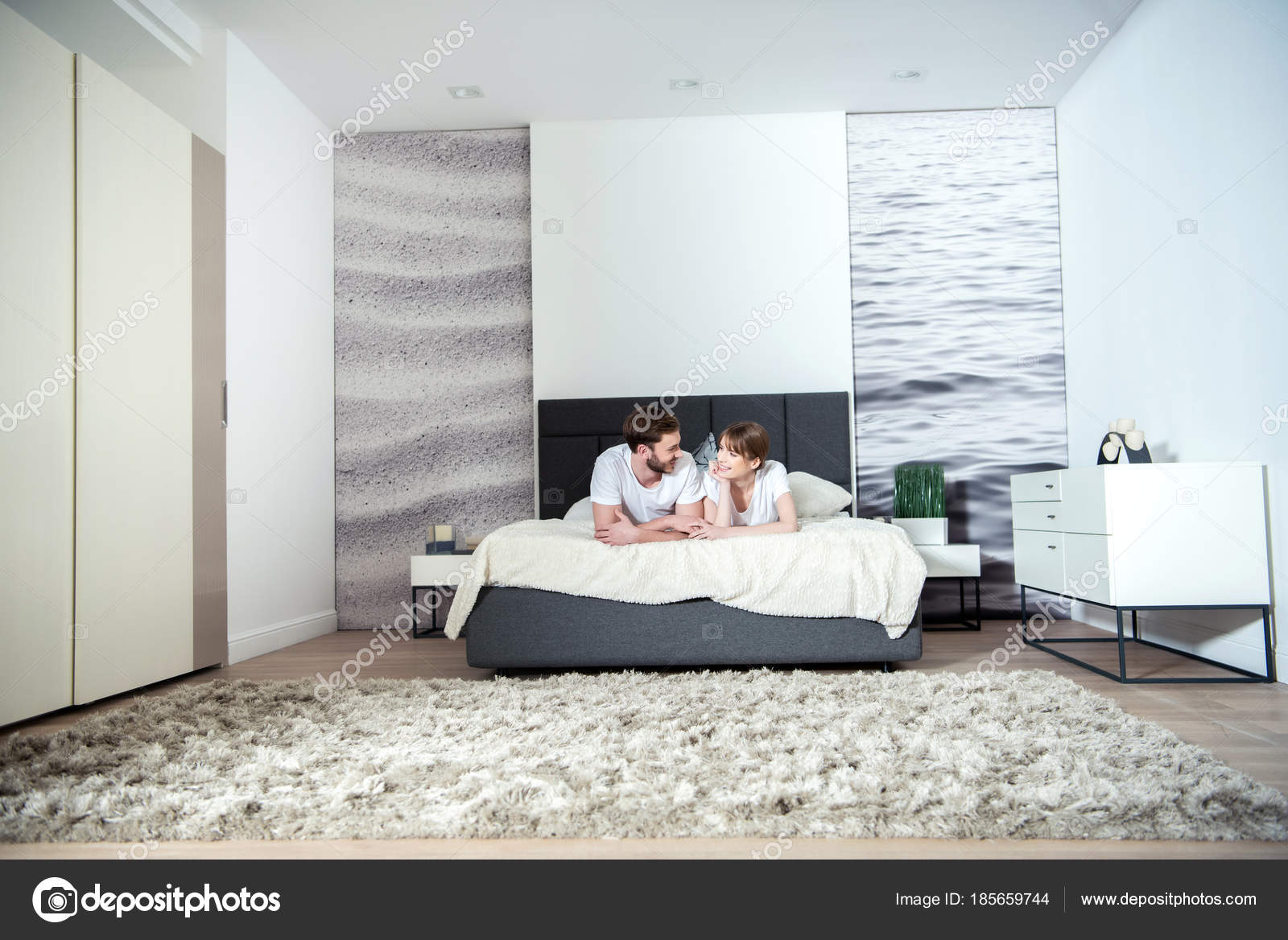 Jovem Casal Deitado Quarto Com Interior Moderno  Stock 