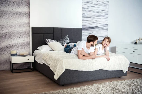 Smiling Young Couple Lying Bedroom Design Interior — Stock Photo, Image