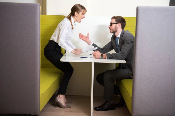 Compañeros Negocios Discutiendo Mientras Están Sentados Mesa Con Papeles Bolígrafos —  Fotos de Stock