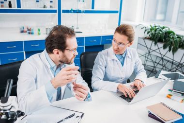 iş yerinde laboratuvar işyerinde tartışırken beyaz kat olarak bilimsel araştırmacılar