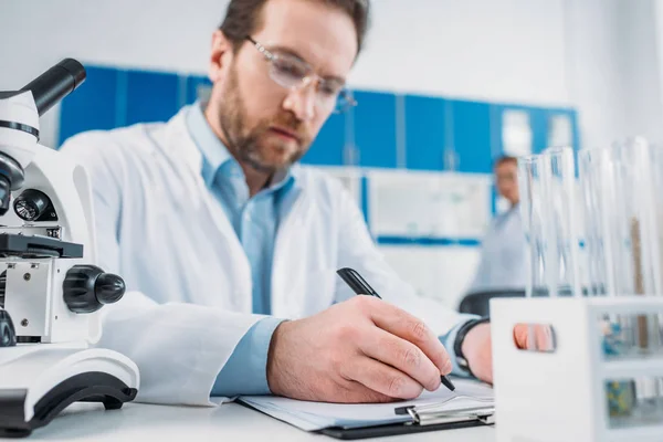 Selective Focus Scientist White Coat Eyeglasses Making Notes Notepad Workplace — Stock Photo, Image