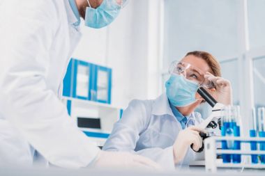 Beyaz kat olarak bilim adamları, medikal eldiven ve bilimsel araştırma birlikte laboratuvarda yapma koruyucu gözlük